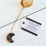 Gold color tea ball infuser for loose leaf tea with moon shaped black agate gemstone crystal wire wrapped with gold wire into tree of life design - includes tag with association and properties of the stone