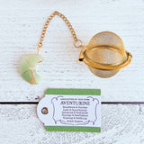 Gold color tea ball infuser for loose leaf tea with moon shaped green aventurine gemstone crystal wire wrapped with gold wire into tree of life design - includes tag with association and properties of the stone