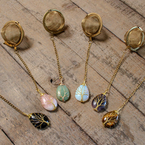 Gold Wire-Wrapped Teardrop Gemstone Tea Ball Infuser - Golden colored tea ball with gold wire wrapped tree on crystal stone tear pendant